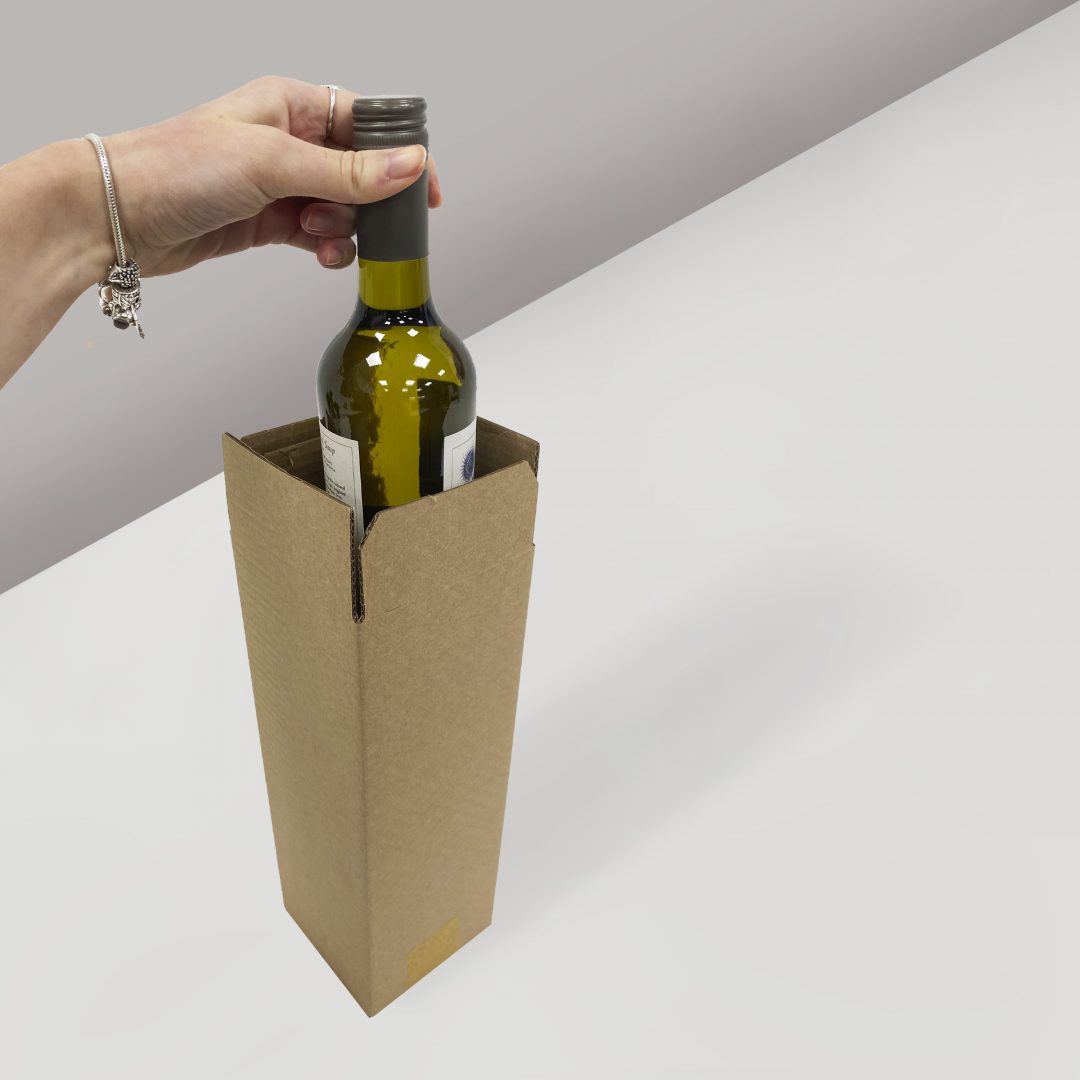 wine bottle being inserted into cardboard box