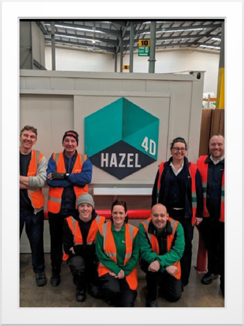 Workers in front of Hazel 4D logo